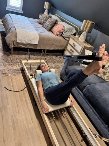 Katie working out on her reformer in her bedroom