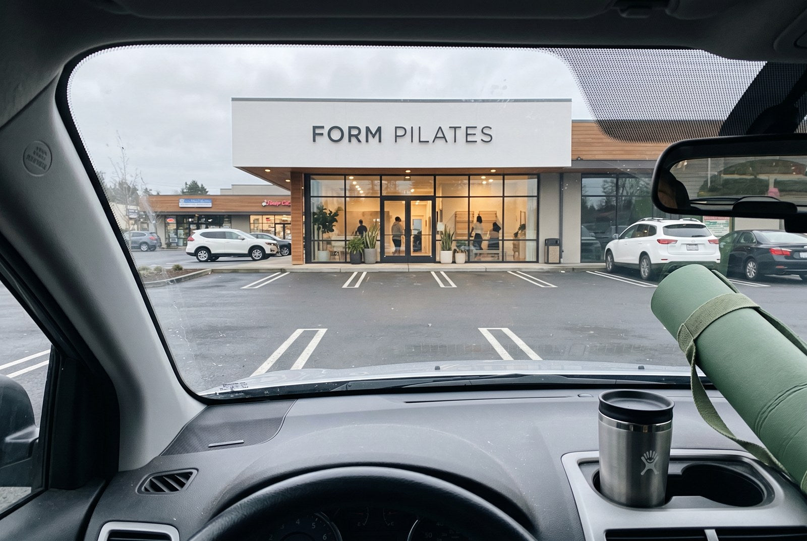 Megan parked outside the studio before another class, yoga mat on the seat